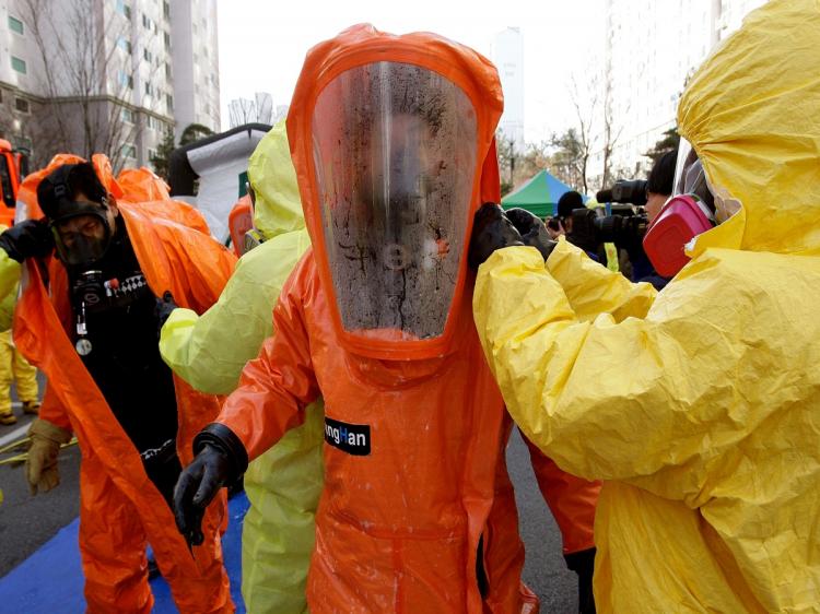 Emergency service personnel in chemical protection clothing participate in a civil defense exercise on December 15, 2010 in Paju, South Korea.  (Chung Sung-Jun/Getty Images)