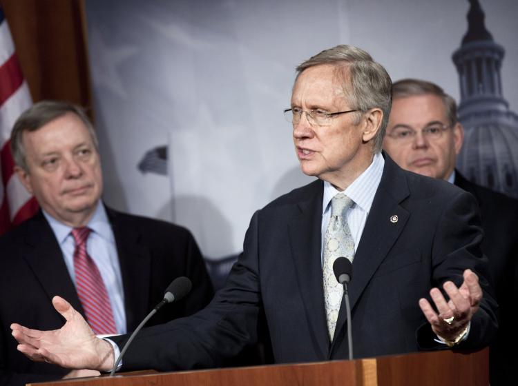 KEEP GOING: Senate Democratic Whip Richard Durbin (D-Ill.) (L) and Sen. Robert Menendez (D-N.J.) (R) listen as Senate Majority Leader Harry Reid (D-Nev.) speaks during a press conference on Capitol Hill Dec. 18, in Washington. (Brendan Smialowski/Getty Images)