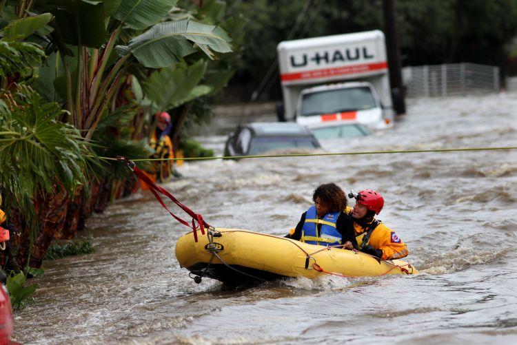 SAN DIEGO, CA - DECEMBER 22: A woman is rescued from floodwaters after being stranded in a hotel after a powerful rainstorm December 22, 2010 in San Diego, California. (Sandy Huffaker/Getty Images)