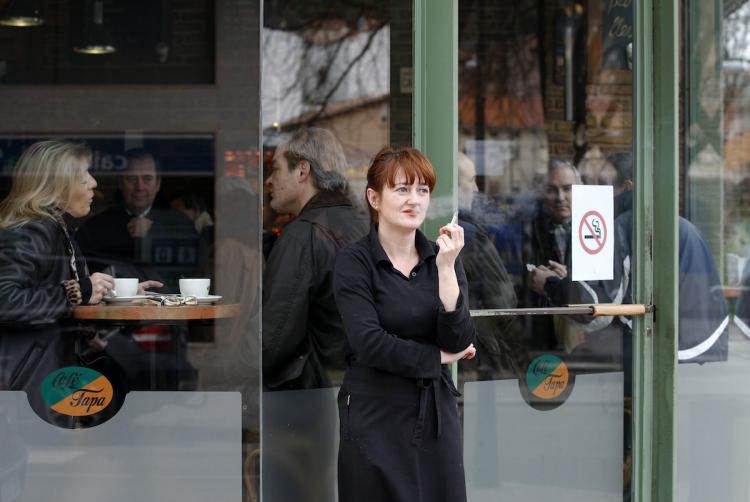 A woman smokes a cigarette outside a cafe in Burgos, Spain on January 2, following the introduction of a new law today banning smoking in all bars, restaurants and public places.   (Cesar Manso/Getty Images )