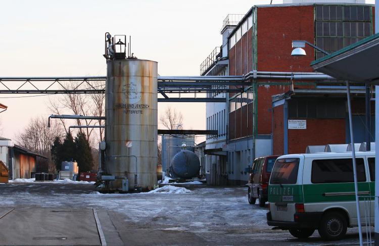 Police stand on the grounds of German animal feeds producer Harles and Jentsch during a raid at the company's production facility on January 4, in Uetersen, Germany. The raid follows disclosures by the company that it had used fats containing dioxin.  ( Joern Pollex/Getty Images)