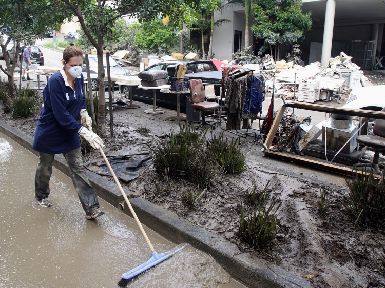 Volunteers help clean up the mess in the suburb of Milton on Jan. 15, 2011 in Brisbane, Australia.  (Bradley Kanaris/Getty Images)
