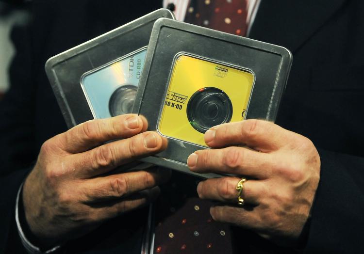 SENSITIVE DATA: Former Swiss banker Rudolf Elmer holds two CDs that he says contain a list of 2,000 companies and individuals that have possibly evaded taxes. Elmer personally handed the CDs over to founder of WikiLeaks Julian Assange on Monday. (CARL DE SOUZA/AFP/Getty Images)