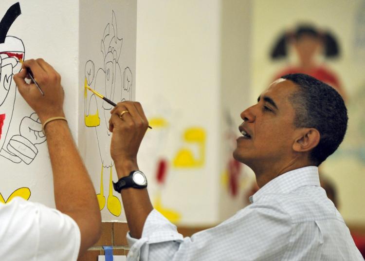 President Barack Obama paints on a wall as he along with First Lady Michelle Obama as their daughters Malia and Sasha take part in a community service project at Stuart Hobson Middle School in celebration of the Martin Luther King, Jr. Day of Service in Washington, DC, on January 17, 2011.  (Jewel Samad/AFP/Getty Images)