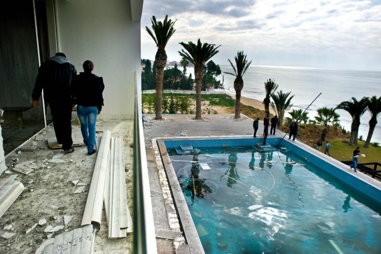People walk on the balcony overlooking the pool as they visit the burnt and looted house that belonged to the nephew of ousted Tunisian President Zine El Abidine Ben Ali in Hammamet, some 37 miles southeast of Tunis, on Jan. 19.  (Martin Bureau/AFP/Getty Images)