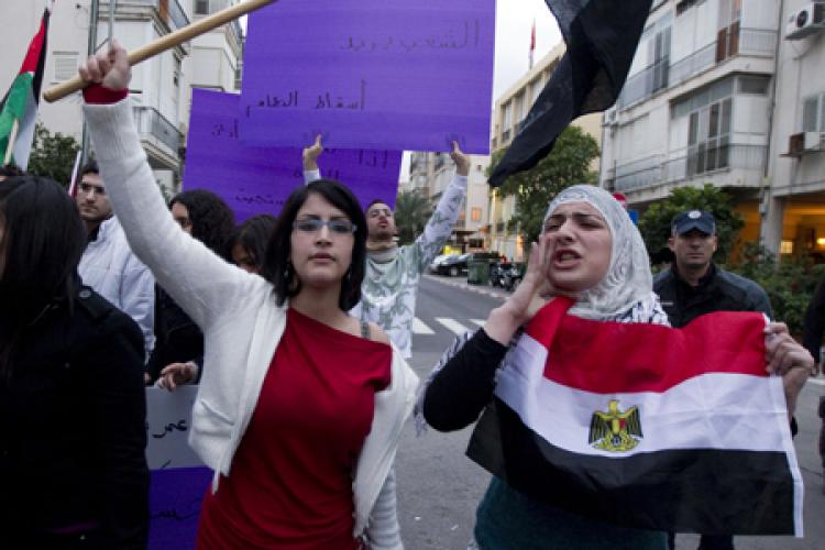 Arab Israelis and Egyptians hold the Egyptian flag as Israeli police stands guard (back R) during a protest near the Egyptian embassy in Tel Aviv on February 1, 2011 in support of the mass demonstrations taking place in Egypt calling for an end of Egyptian President Hosni Mubarak's regime. (Jack Guez/Getty Images )