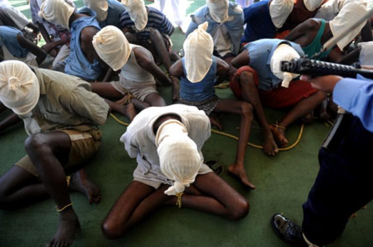 Suspected Somali pirates sit with their faces covered during a media interaction on board an Indian Coast guard ship off the coast of Mumbai on February 10, 2011. Twenty eight suspected pirates were brought to Mumbai on February 10 for questioning over an alleged attack as Coastguard Inspector General S.P.S. (Punit Paranipe/Getty Images)
