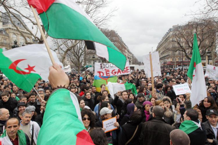 People hold Algerian national flags, on February 12, 2011 at the republique square in Paris, during a demonstation to call for a regime change in Algeria, a day after the fall of Egyptian strongman Hosni Mubarak.  (Pierre Verdy/Getty Images )
