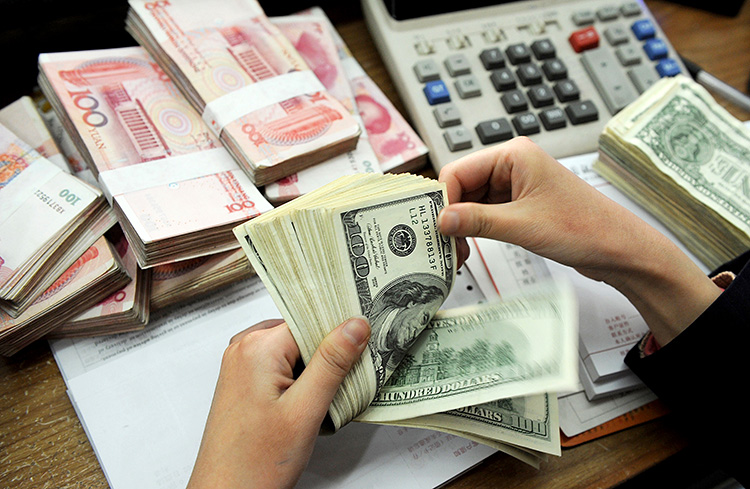 Stacks of US dollars and Chinese 100-yuan notes