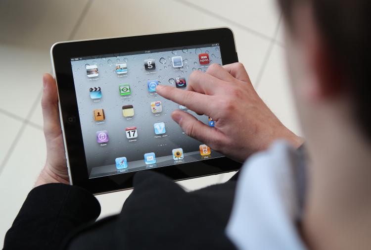 A man uses an Apple iPad tablet. Apple uses product placement regularly as part of its marketing strategies. Worldwide iPad sales are expected to amount to 20 million in 2012. (Photo Illustration by Peter Macdiarmid/Getty Images)