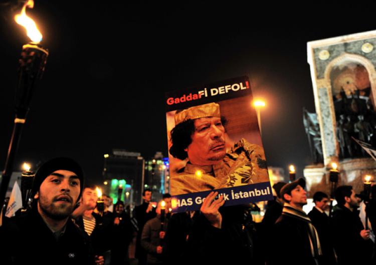 A demonstrator holds a poster reading 'Gaddafi Get Out' and showing Libya's leader Muammar Gaddafi during a protest against his regime at Taksim Square in Istanbul, Turkey, on February 22, 2011.   (Mustafa Ozer/Getty Images )