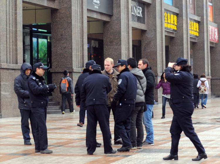 Chinese police surround a group of foreign journalists as security is ramped up, with at least 300 hundred uniformed police guarding the entrance to the Jasmine rally site, designated in an online appeal, in the Wangfujing shopping street in central Beijing, China. (AFP/Getty Images)