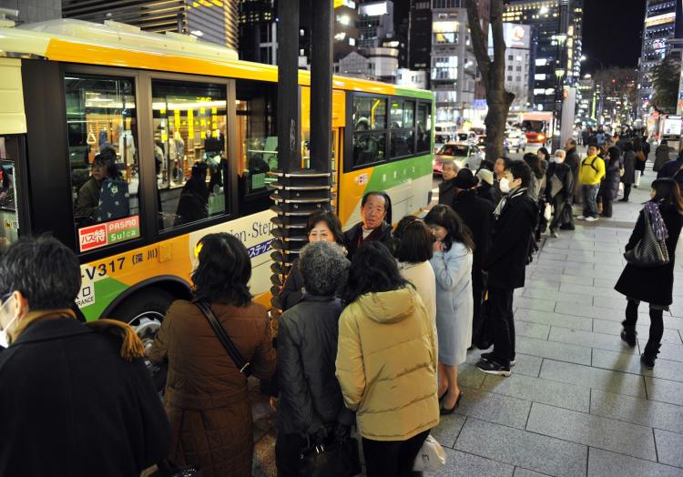 People make a long line to board buses in Tokyo as commuter trains stopped their services in the Tokyo metropolitan area on March 11, 2011. (Yoshikazu Tsuno/AFP/Getty Images)