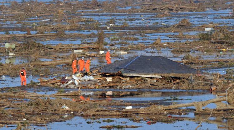 Rescue workers check the remains of a tsunami devastated house for people in Natori in Miyagi prefecture on March 13, 2011. (Mike Clarke/AFP/Getty Images)