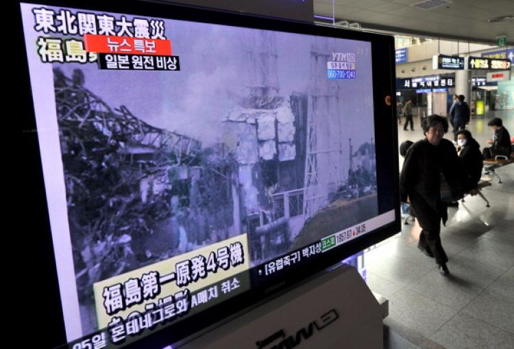 A South Korean passenger walks past a TV that is reporting an explosion and of Japan's Fukushima Daiichi Nuclear Power Plant last month. (Jung Yeon-Je/AFP/Getty Images)