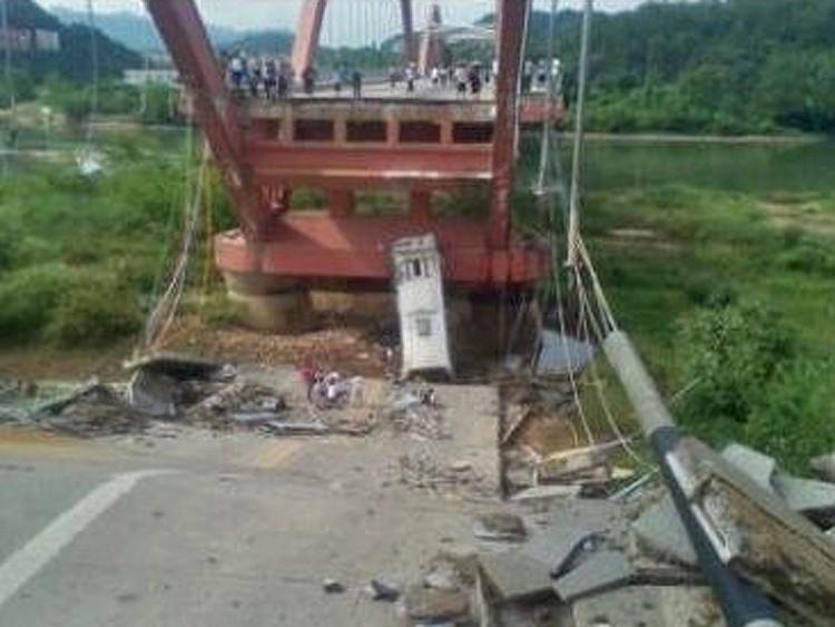 One third of the Wuyi mountain bridge in Fujian province collapsed on July 14, 2011, causing a full tourist bus to fall off the bridge. The bus driver died at the scene. (Weibo.com)