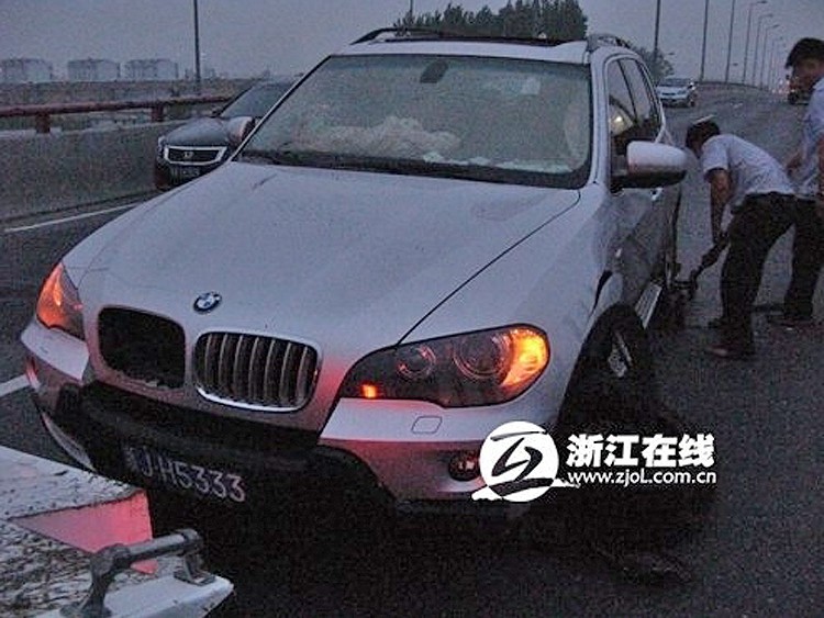 A BMW got stuck in a hole in the Third Qianjiang River Bridge in Hangzhou at 2 a.m. on July 15, 2011.  (Weibo.com)