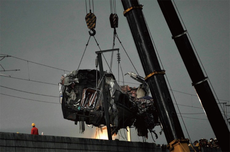 A mangled train car is hoisted away after the deadly Wenzhou collision.  (Getty Images)