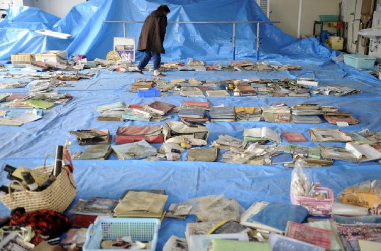 Japan: A survivor checks salvaged memorial pictures and goods on display at a corner of the town hall in Yamada town, Iwate prefecture on March 25, 2011.  (Toshifumo Kitamura/AFP/Getty Images)