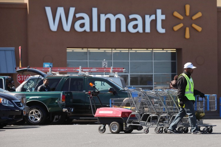 A man pushes carriages outside of a Walmart store