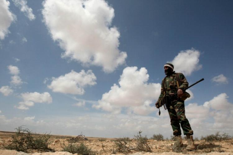 An armed rebel fighter stands in the waste land close to the entrance to the strategic oil town of Brega on April 01, 2011. (Mahmud Hams/AFP/Getty Images)