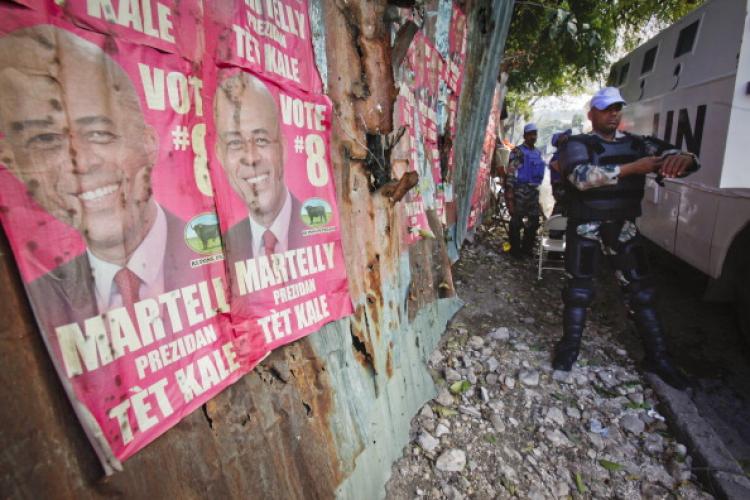 United Nations troops from India put on protective gear near posters of presidential candidate Michel 'Sweet Micky' Martelly near the headquarters of the Provision Electoral Council April 4, 2011 in Petionville, Haiti. (Lee Celano/Getty Images)