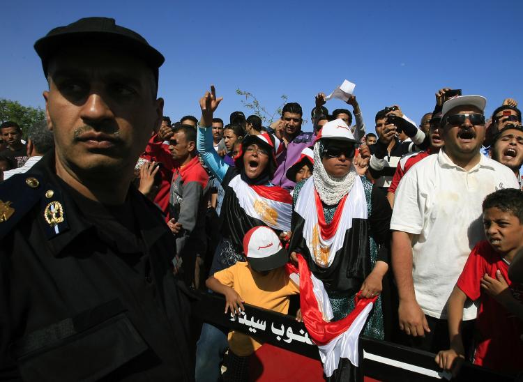 An Egyptian policeman stands guard as protesters shout slogans against ousted President Hosni Mubarak outside the Sharm el-Sheikh International Hospital in the resort town on April 13. Mubarak was admitted to intensive care after he reportedly suffered a heart attack during questioning by prosecutors.  (AFP/Getty Images)