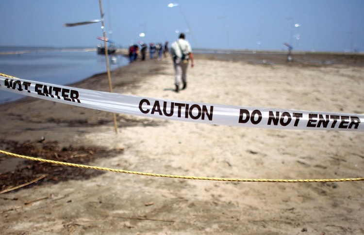 DAMAGED BEACHES: A Louisiana Wildlife and Fisheries officer walks along an oiled beach on April 19 at South Pass in southern Louisiana. Most beach water pollution involves aged sewage systems and rainwater runoff. The Environmental Protection Agency (EPA) recently overhauled the Clean Water Act, and agreed to conduct new surveys. (John Moore/Getty Images)