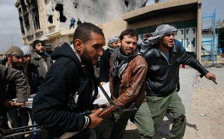 A photo taken by slain photographer Chris Hondros shows Libyan rebel fighters carrying out a comrade wounded during an effort to dislodge some ensconced government loyalist troops on April 20, 2011 in Misrata, Libya. Hondros was killed on Wednesday. (Chris Hondros/Getty Images)