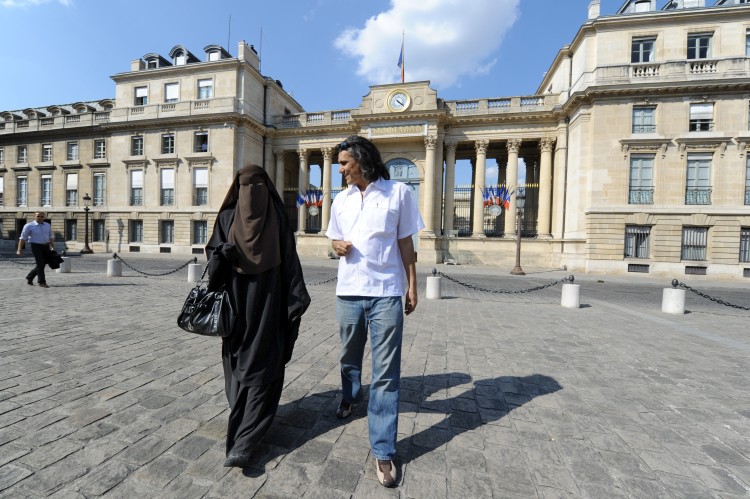 A woman wearing a niqab (L) and real estate magnate Rachid Nekkaz (R) walk in front of the French National Assembly during a symbolic protest against France's ban on wearing full-face veils in public, April 20 in Paris. (Mehdi Fedouach/AFP/Getty Images)