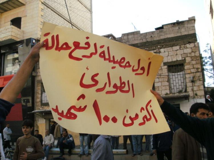 Syrians protest in the city of Banias holding up a sign that reads in Arabic: 'The first results in lifting the state of emergency is over 100 deaths' on April 26, 2011. (AFP/Getty Images)