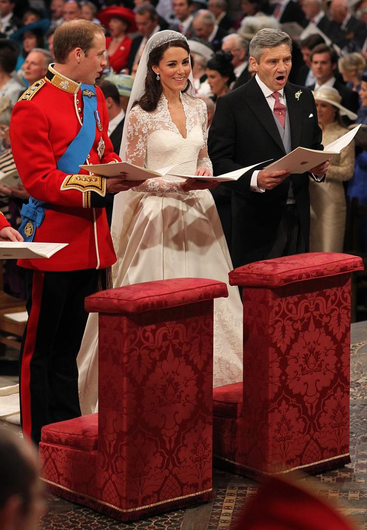 Prince William sings beside his bride Catherine Middleton and her father Michael Middleton on Friday in London. (Dominic Lipinski - WPA Pool/Getty Images)