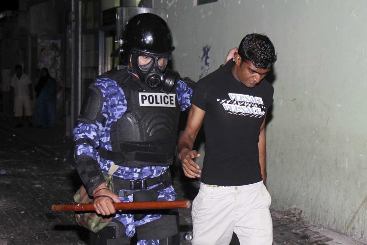 A Maldivian activist is arrested after police dispersed the protests which went overnight over the rise of the commodities's price and the dollar exchange rate in Male on May 1.  (Strdel/AFP/Getty Images)