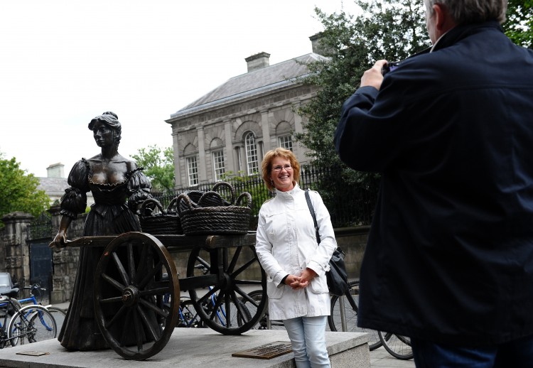 A tourist poses for a picture in front of the statue of Molly Malone in Grafton Street, Dublin, Ireland. (Getty Images) A tourist poses for a picture in front of the statue of Molly Malone in Grafton Street, Dublin, Ireland. (Getty Images)