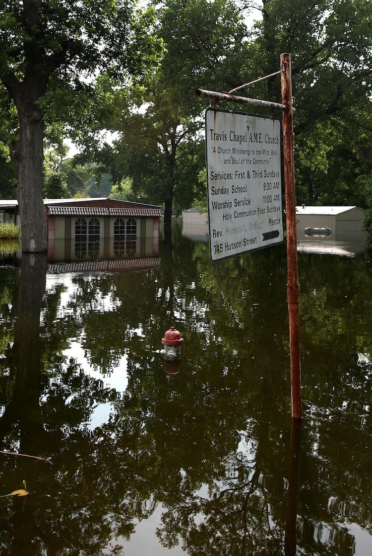 SEVERE FLOODING: Homes and a church sign sit in the Mississippi River floodwaters May 21 in Vicksburg, Miss. The National Wildlife Federation (NWF) says government policies have worsened the flooding and offer suggestions for policymakers to avoid future problems.   (Mario Tama/Getty Images)