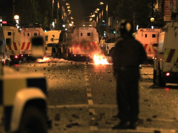 A policeman stands burning amid debris and police vehicles in east Belfast, Northern Ireland on June 21, 2011.  (Peter Muhly/AFP/Getty Images)