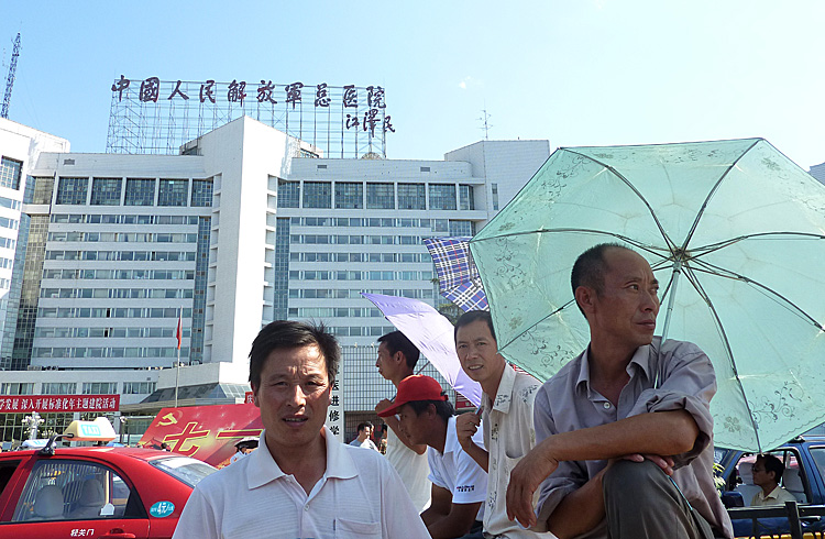 Men stand at the entrance of the 301 Military Hospital in Beijing