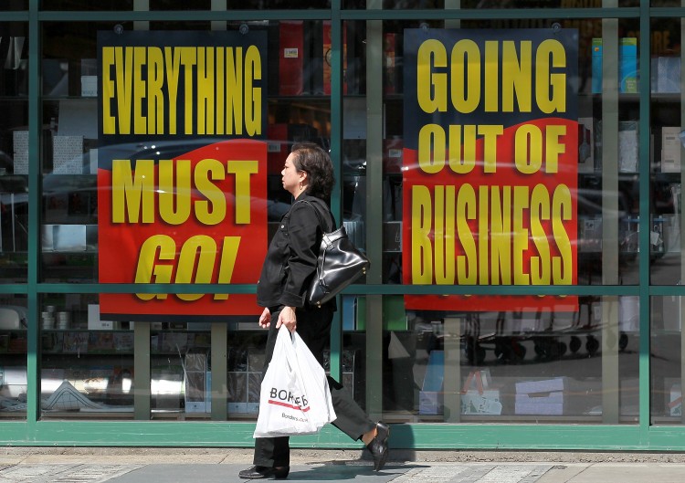 CLOSING DOORS: A Borders customer walks by signs advertising a going-out-of-business sale at a Borders bookstore on July 22 in San Francisco, California. Borders is liquidating inventory at all its remaining stores.  (Justin Sullivan/Getty Images)