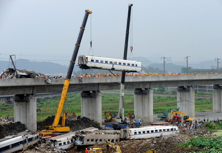 Following a fatal bullet train crash in eastern China, excavators arrive at the site to bury the fallen train cars. (STR/AFP/Getty Images)