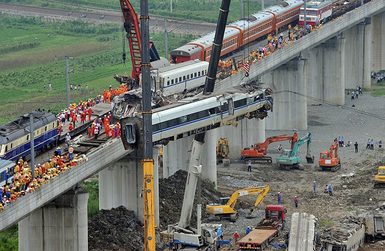 Workers clear wreckage of mangled carriages after a Chinese high-speed train derailed when it was hit from behind by another express late on July 23 in the town of Shuangyu near the city of Wenzhou, in eastern China's Zhejiang province. (AFP/Getty Images)