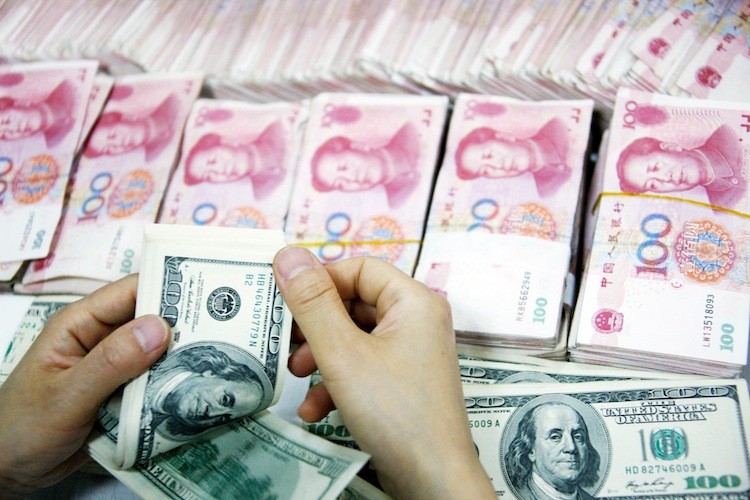 An employee counts money at a branch of Industrial and Commercial Bank of China Limited (ICBC) on July 26 in Huaibei, China. A more long-term intention by the Chinese regime is to make its currency an international reserve currency and within time unseat the U.S. dollar.  (ChinaFotoPress/Getty Images)