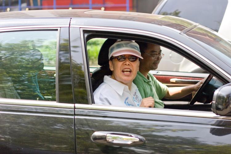 Court Adjourned: One of the Flushing assailants screams out of the window of a car following a court hearing on July 18. (Dayin Chen/The Epoch Times)