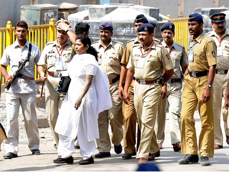 Indian lawyer Anjali Waghmare (C/white) walks past security personnel as she leaves The Arthur Road jail in Mumbai on April 15, 2009. (Sajjad Hussain/AFP/Getty Images)