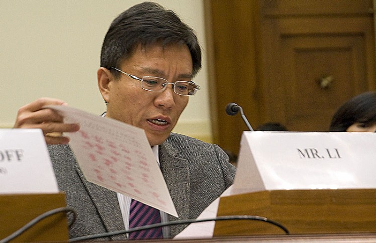 Li Hai holds up a copy of a document with thumbprints of villagers from China