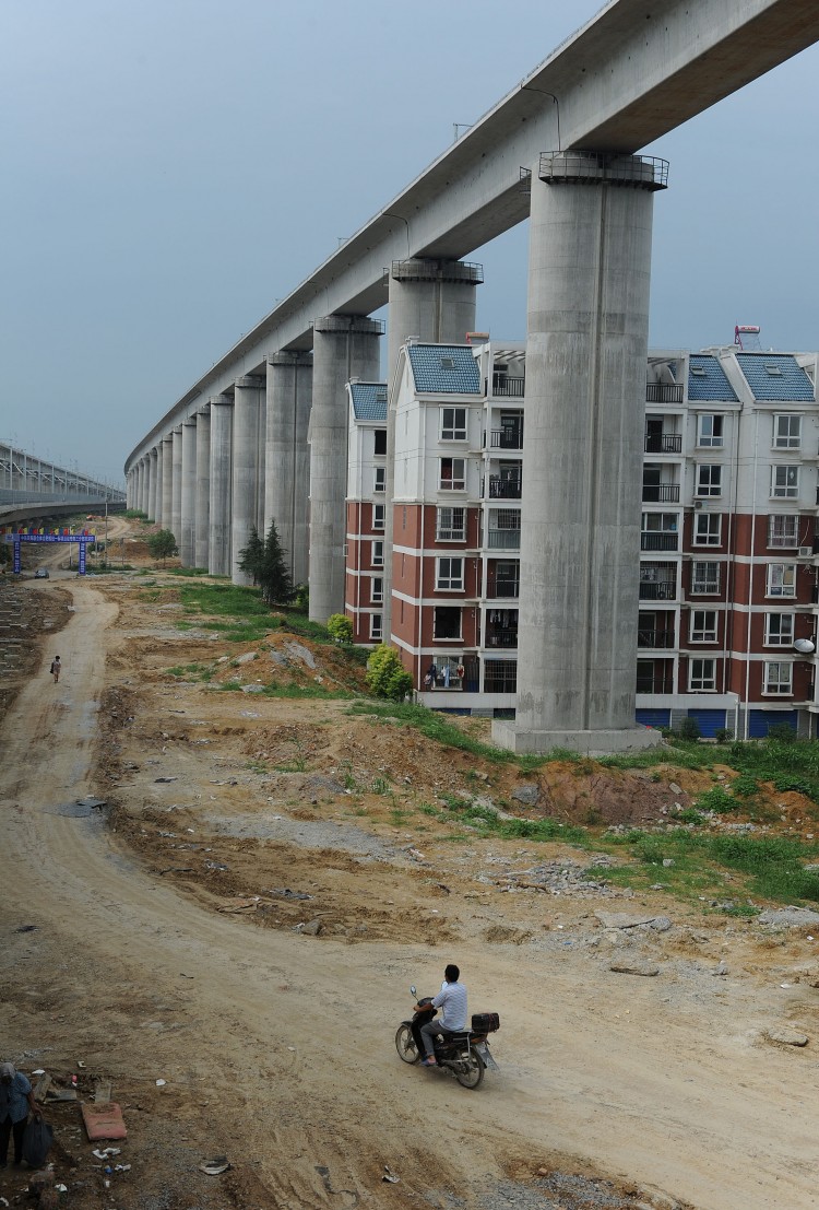 Residential buildings sitting between concrete supports of a high-speed train line in Shuandun county, in Hefei, in east China's Anhui province.  (STR/AFP/Getty Images)