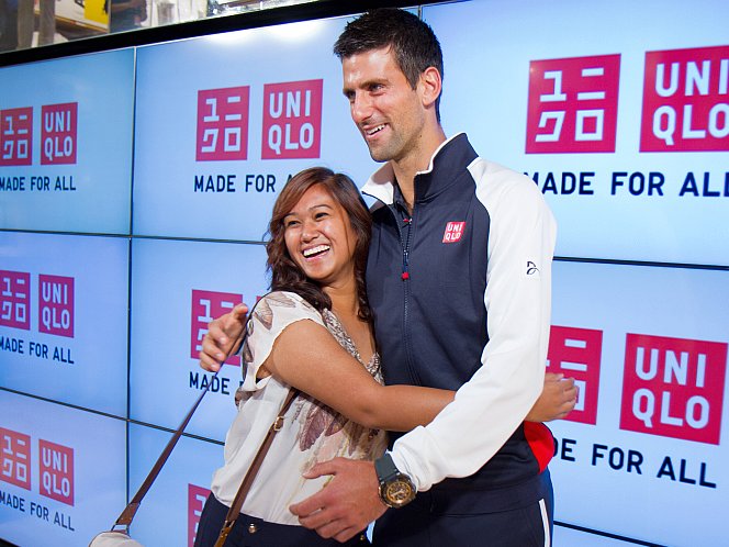 Professional tennis player, Novak Djokovic, hugs a fan as hundreds more lined up outside at Uniqlo's Manhattan Flagship store for the unavailing of the store's new line of tennis apparel on Aug. 22. (Benjamin Chasteen/The Epoch Times)