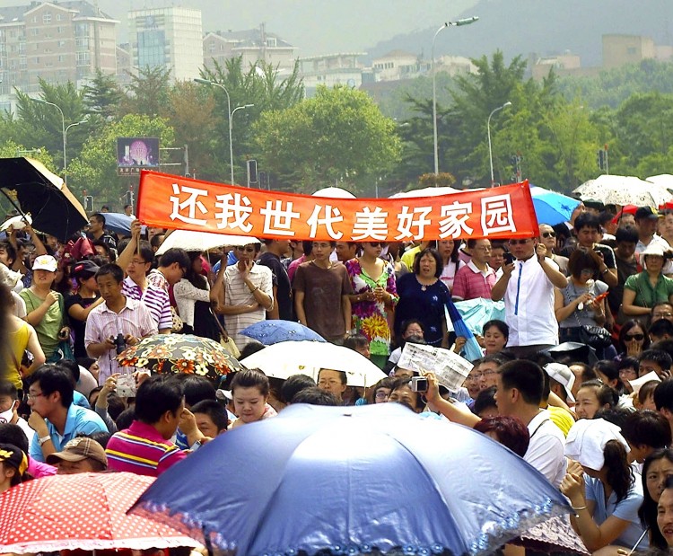 Thousands of Chinese people protest demanding that the Fujia chemical plant be moved over pollution fears with banners saying 'Give back generations of homeland of Dalian' in Dalian, on August 14. (STR/AFP/Getty Images)