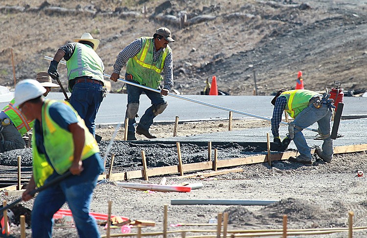 Construction workers smooth concrete for a walkway at a new housing development on Aug. 16 in Petaluma, Calif. The World Economic Forum's annual global competitiveness report showed that the United States fell one place to fifth in the world in business competitiveness. (Justin Sullivan/Getty Images)