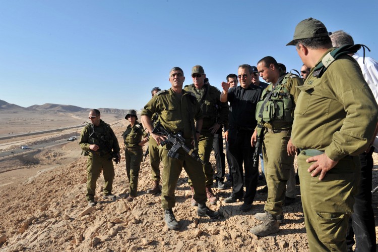 In this handout image provided by the Israeli Defence Ministry, Israeli Defense Minister Ehud Barak visits the scene following series of coordinated gun and roadside bomb attacks against miltary and civilian targets near the Israeli-Egyptian border on August 18. (Israeli Defense Ministry via Getty Images)