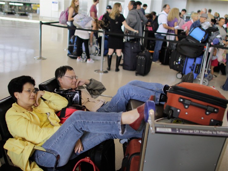 STRANDED: Elizabeth Nguyen and her husband Christian Chan rest together after their connecting flight was canceled by Continental Airlines, after Hurricane Irene, at Newark airport in Newark, N.J., Aug. 29.  (Joe Raedle/Getty Images)